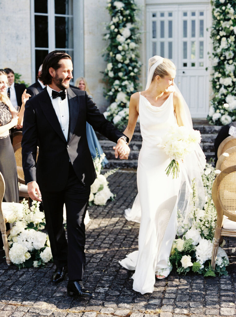 Tristan and Meredith walking hand in hand down the aisle