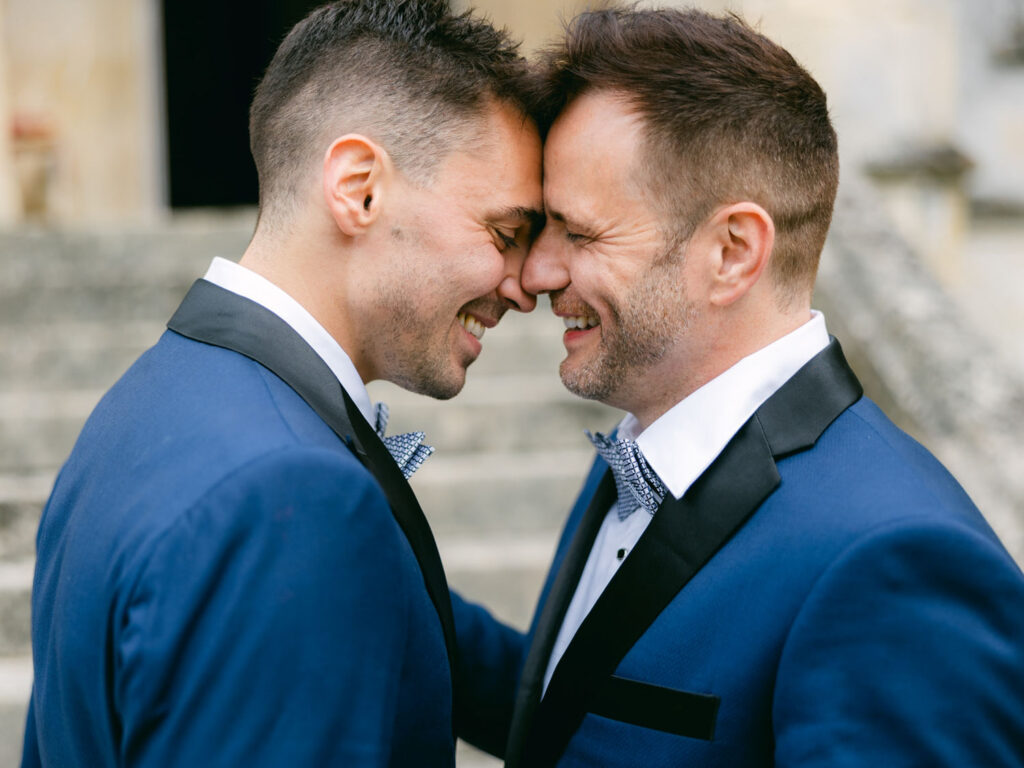 Kevin and Steven sharing a tender moment, touching foreheads and smiling during their wedding day