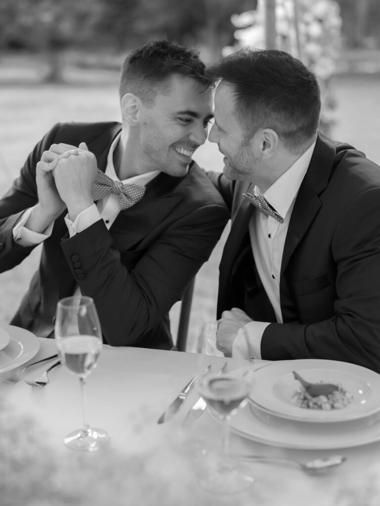 Kevin and Steven sharing a joyful and intimate moment during their wedding reception, smiling and leaning in close