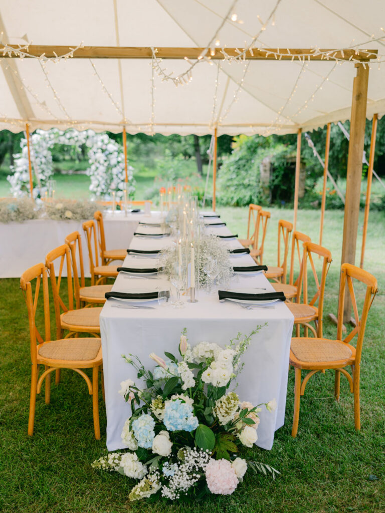 Elegant outdoor reception setup with floral centerpieces and twinkling lights at Kevin and Steven's wedding in France