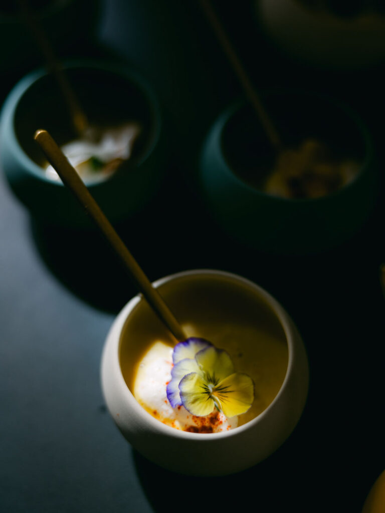 Elegant bowls of creamy soup garnished with edible flowers, served at Kevin and Steven's wedding in France