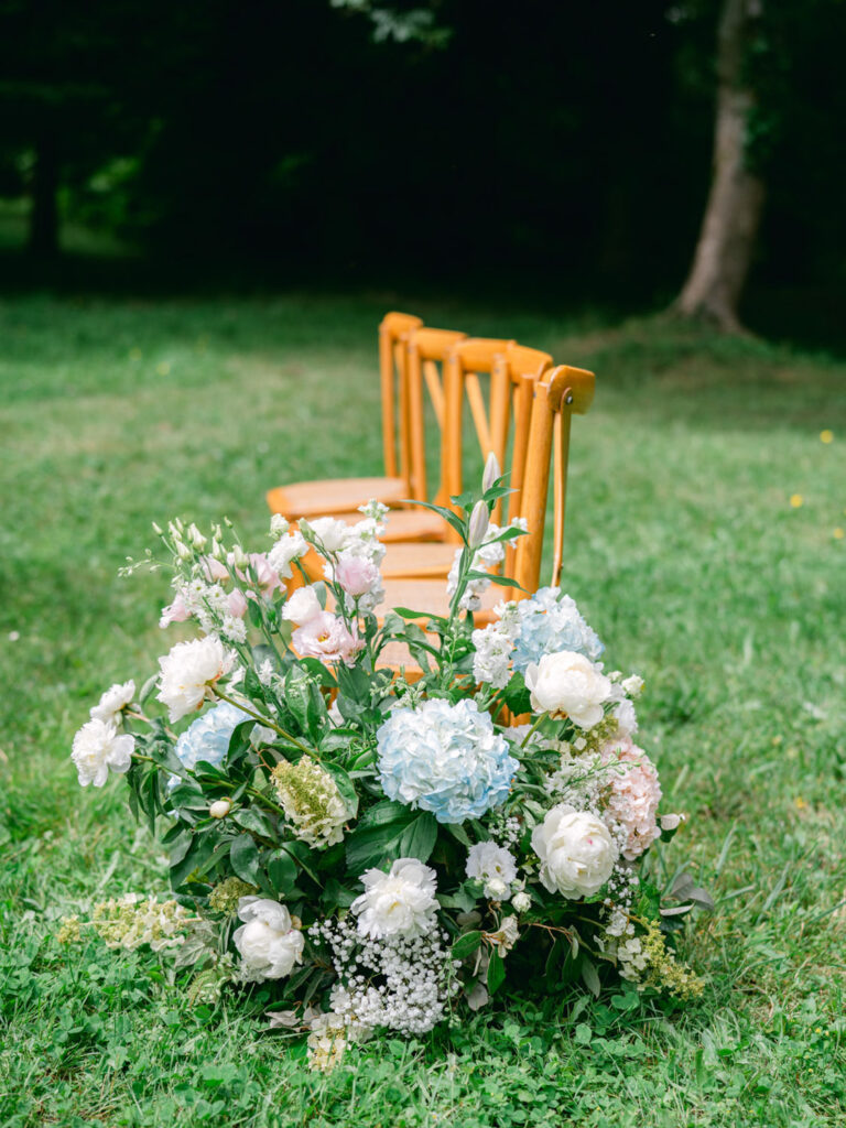 Lush floral arrangements decorate the aisle at Kevin and Steven's outdoor wedding in France