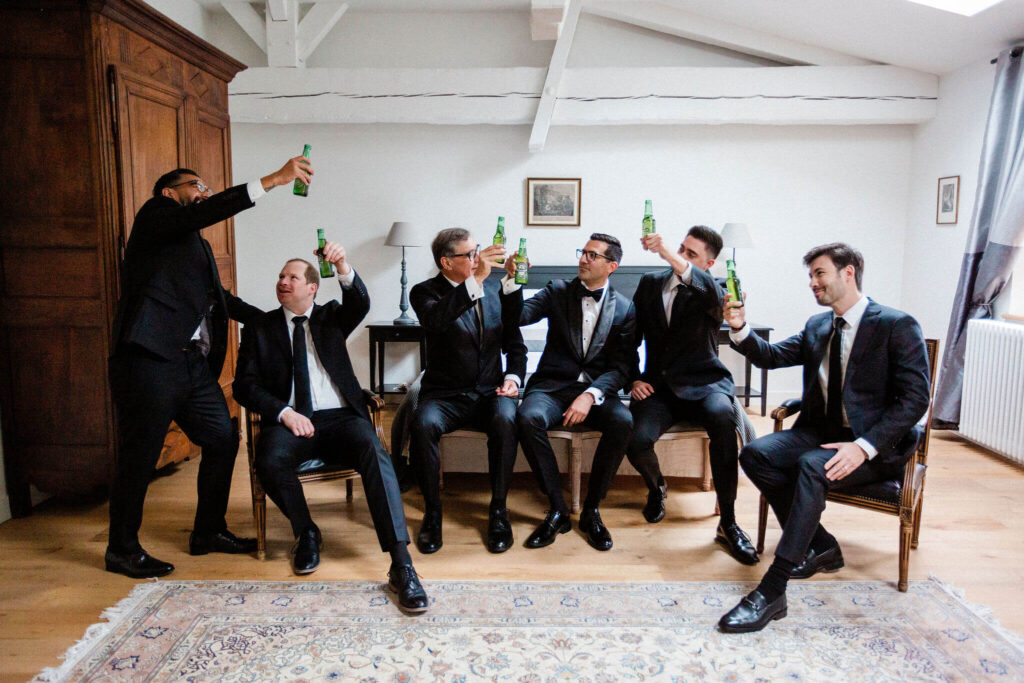 Groomsmen raising their drinks in celebration before the wedding