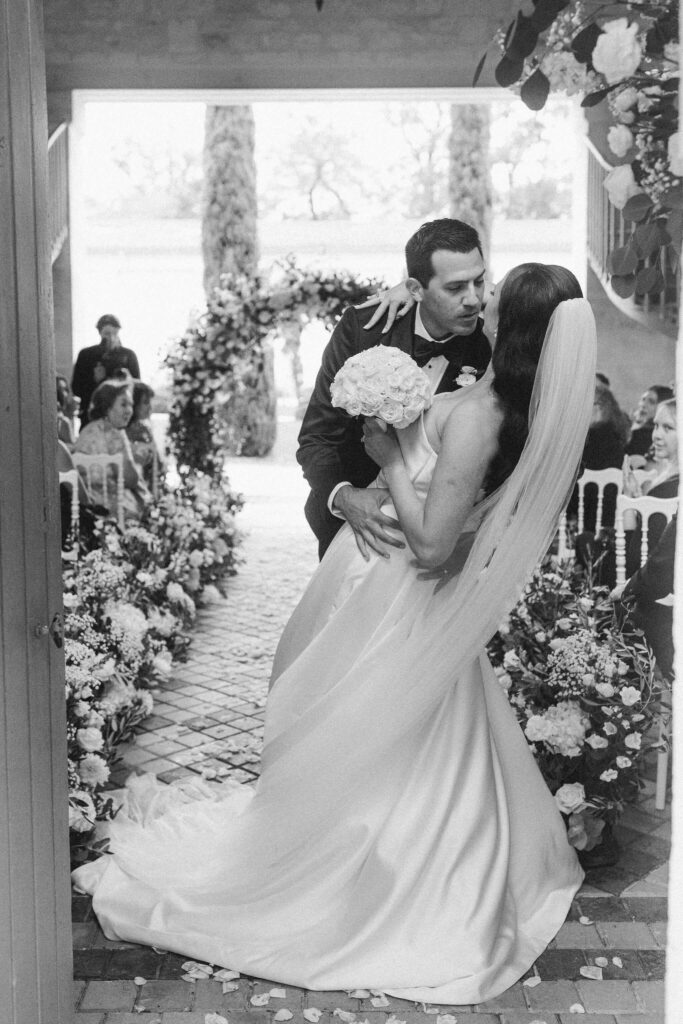 Bride and groom sharing a romantic kiss during their wedding ceremony