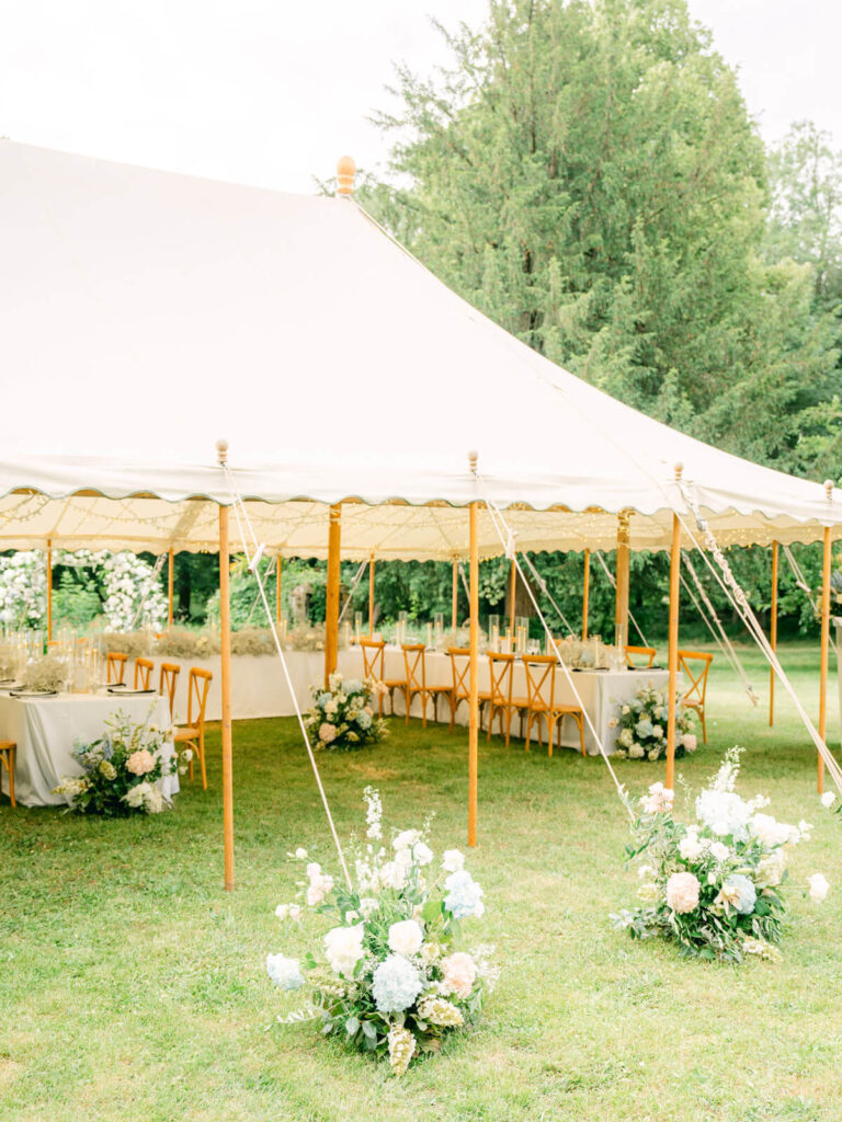 Outdoor tent with elegant floral decor for a rainy wedding day