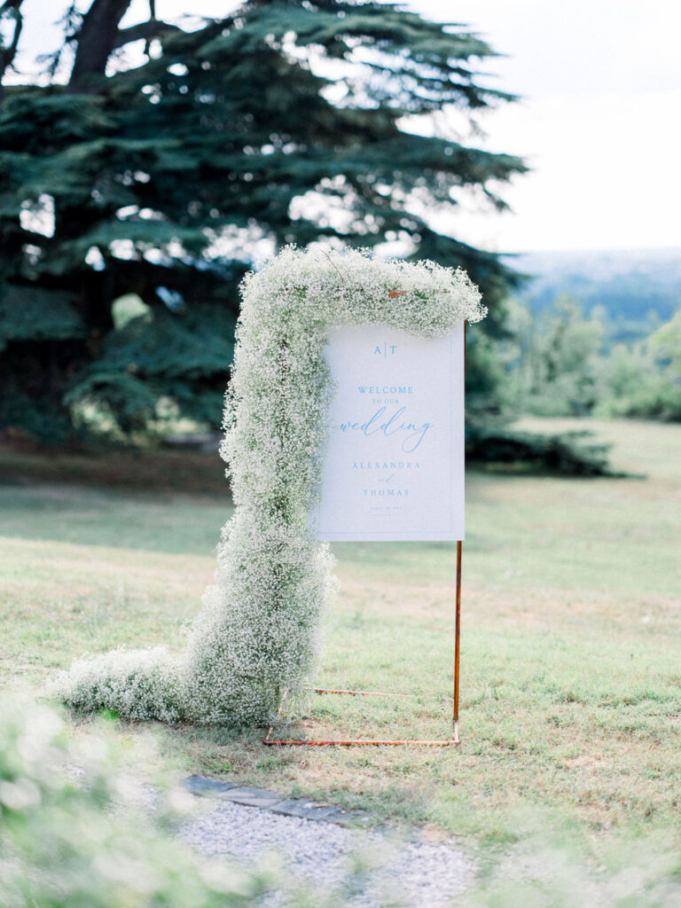 Close-up of the welcome sign adorned with baby’s breath flowers