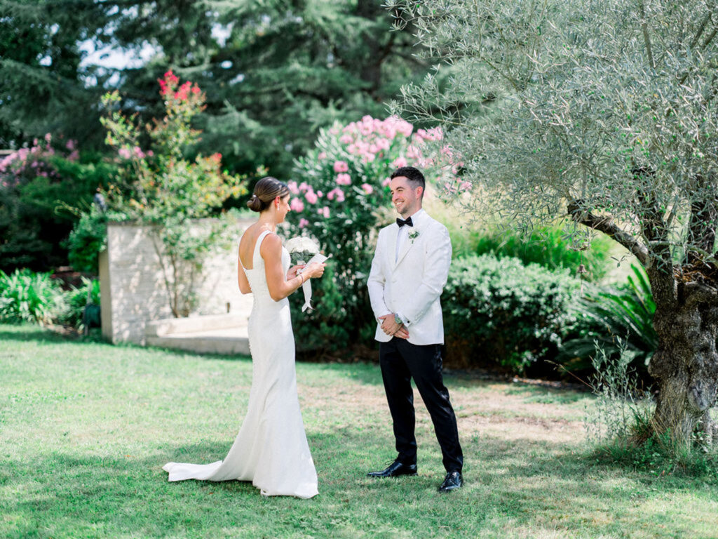 Bride and groom’s first look surrounded by lush greenery