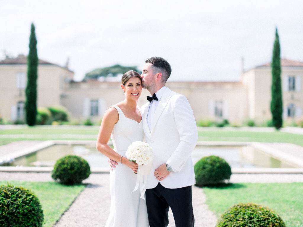 Bride and groom sharing a kiss in the Château Gassies courtyard