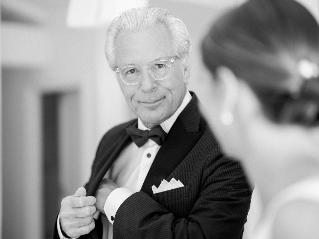 Father of the bride fixing his suit while looking at the bride