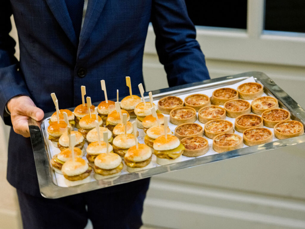 Mini sliders and quiches elegantly displayed on a silver tray