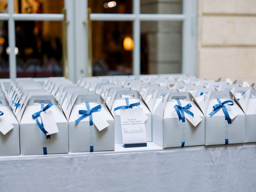 Wedding favors neatly arranged in white boxes with blue ribbons