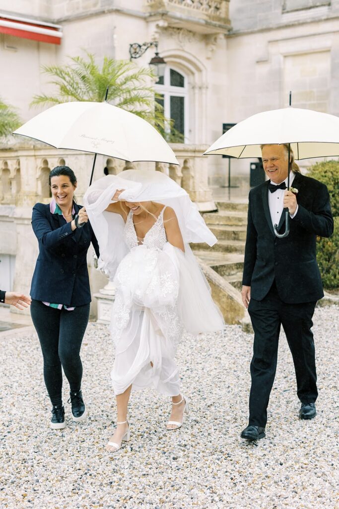 Bride shielded by an umbrella on her wedding