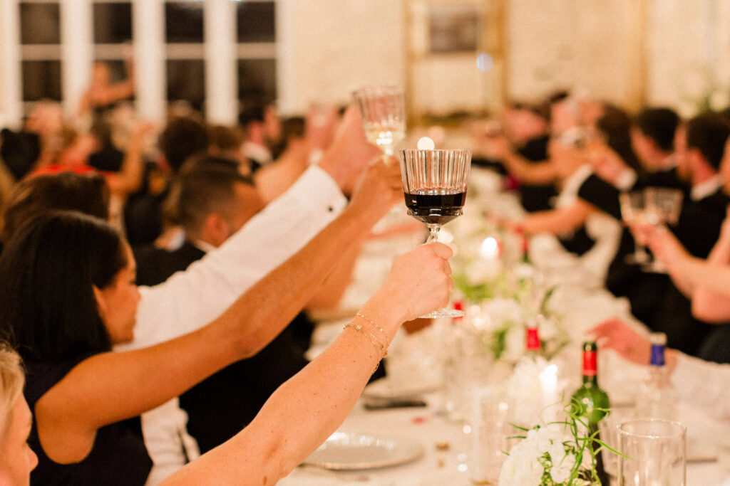 beautiful moment of cheers as friends and family celebrate a magical evening at a Bordeaux wedding party.