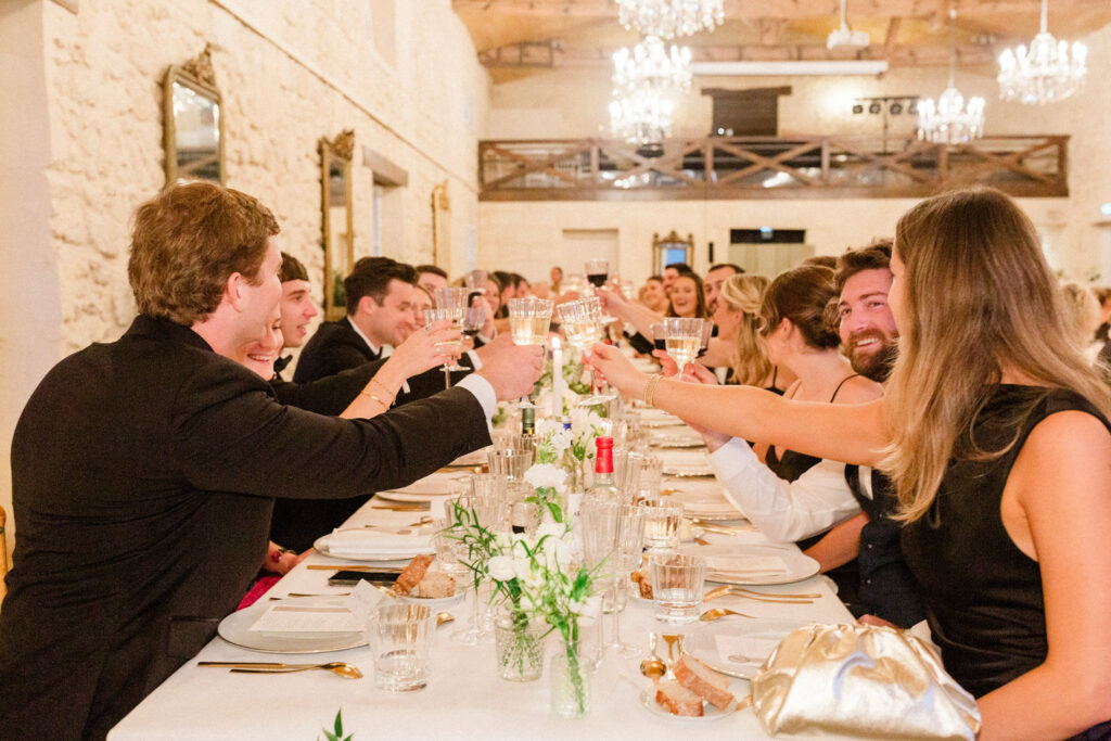 A long, elegant reception table filled with laughter, wine, and candlelight at Lauren & Richie's Bordeaux wedding