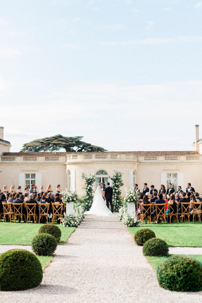 A panoramic view of the elegant outdoor ceremony, where friends and family witness the couple’s special moment