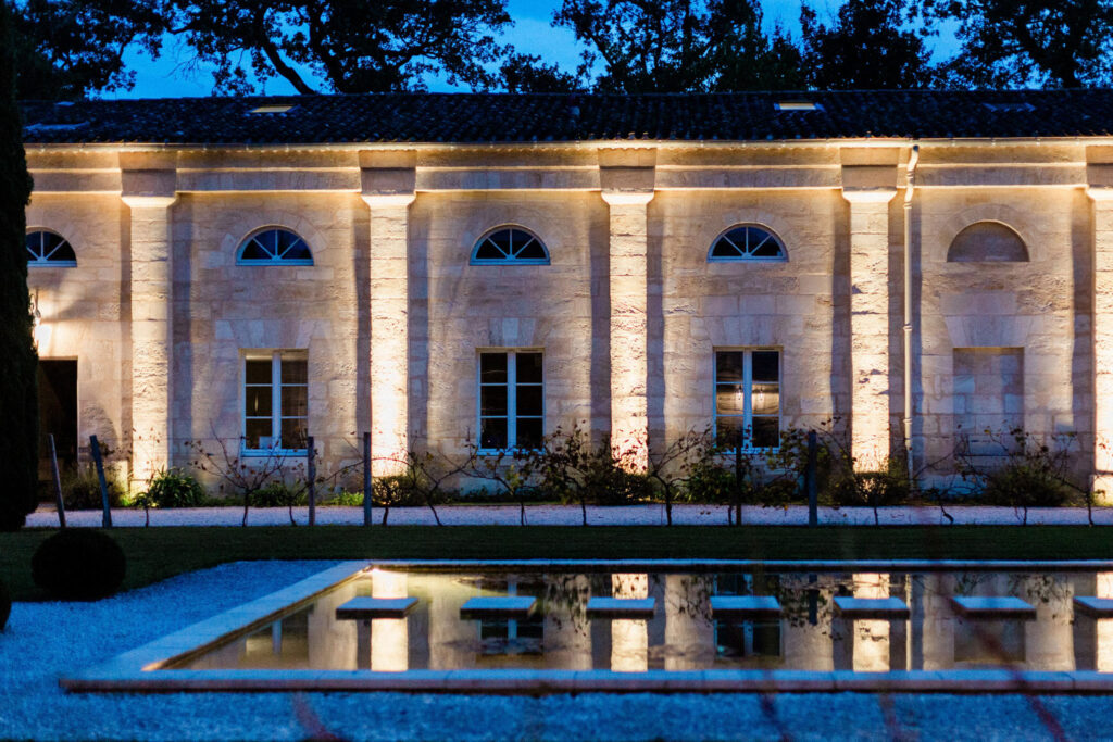 A stunning château facade illuminated at night, creating a magical wedding atmosphere