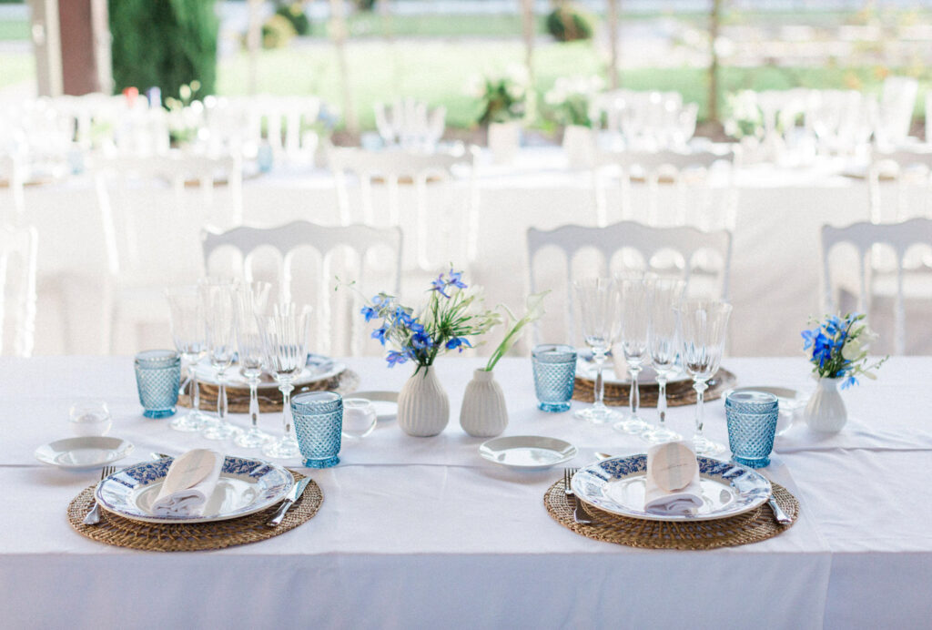 A refined table setting with blue accents and delicate florals for a Bordeaux wedding party