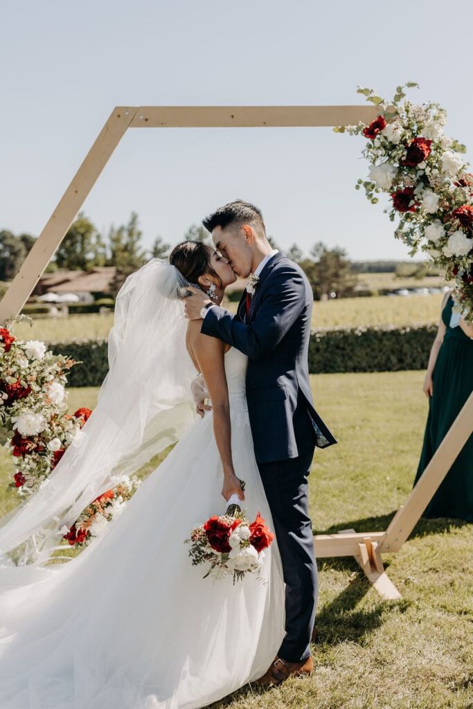 Bride and groom’s first kiss at a Bordeaux outdoor wedding ceremony captured beautifully.