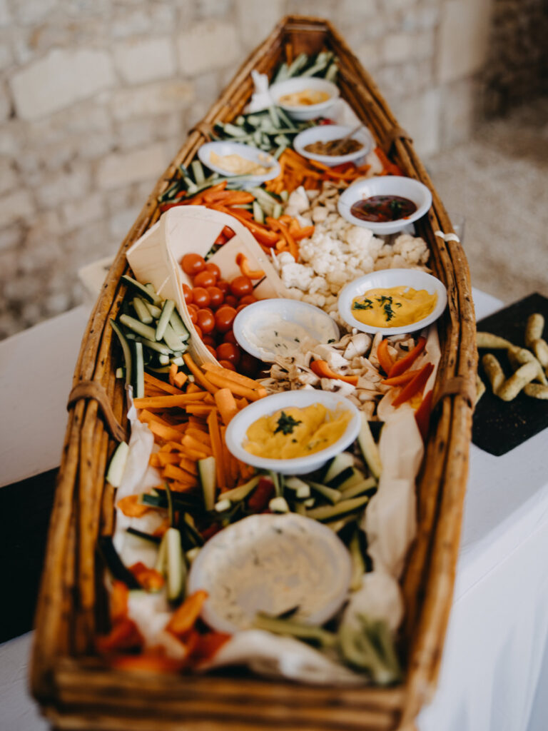 Colorful vegetable and dip boat display for a casual welcome party.