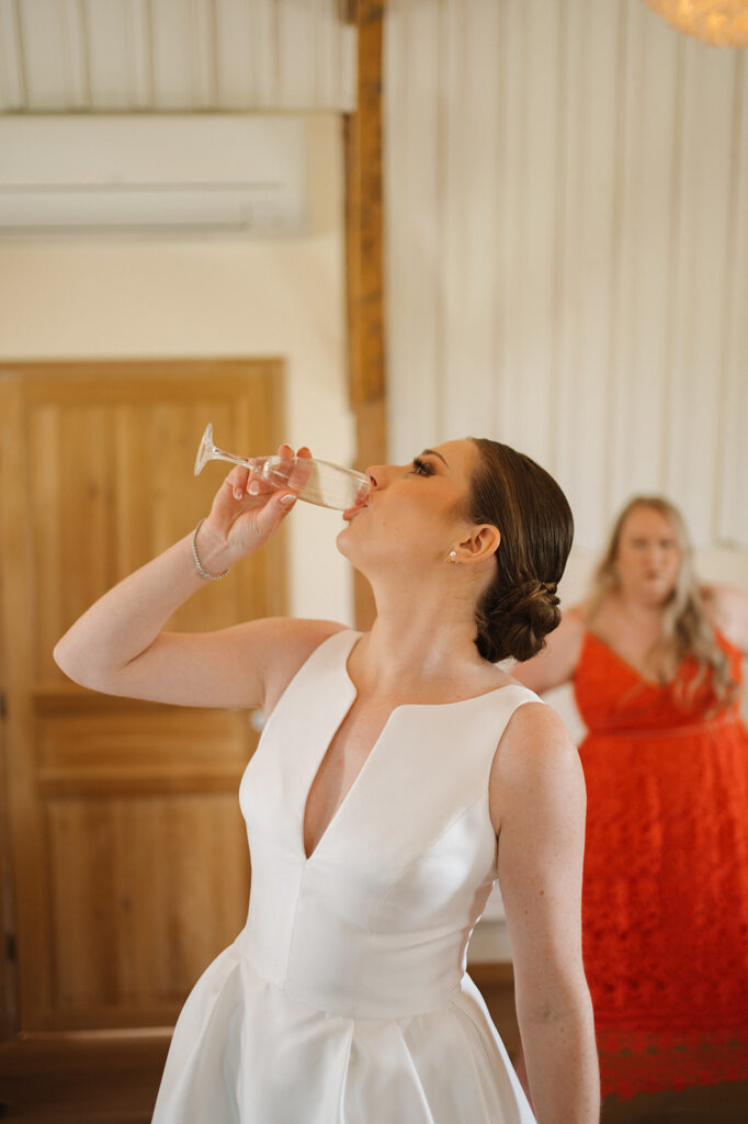 The bride takes a celebratory sip of champagne before the ceremony.