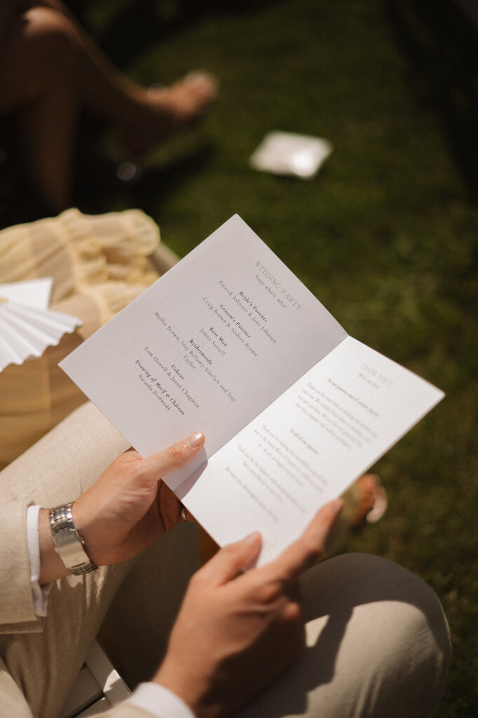 A guest holds a program listing the wedding party and a note of thanks.