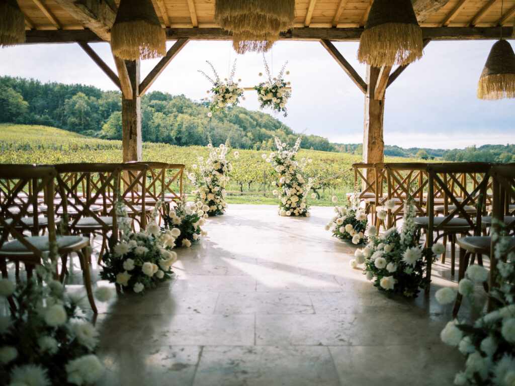 Covered outdoor wedding ceremony overlooking French vineyards.