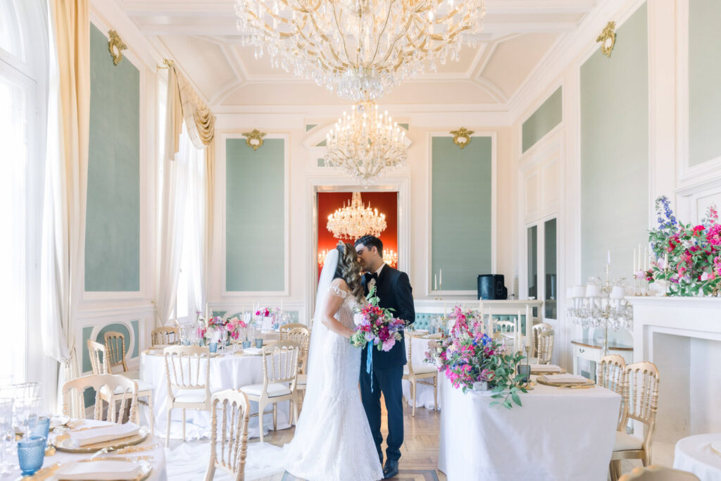 Wedding couple in an opulent French dining room surrounded by florals