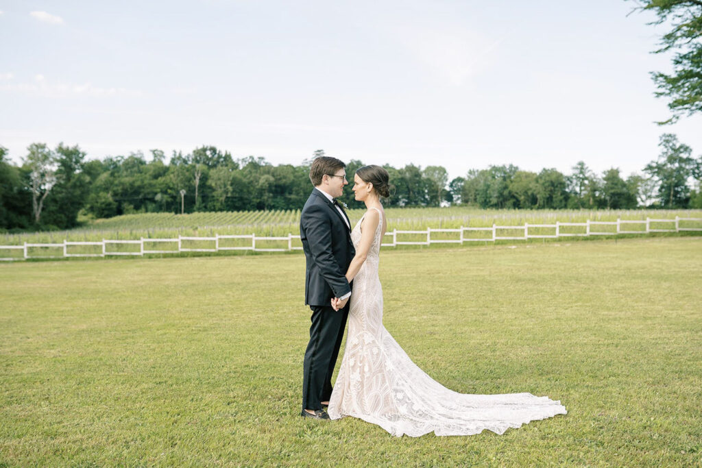 Bride and groom share a quiet moment in front of vineyard views.