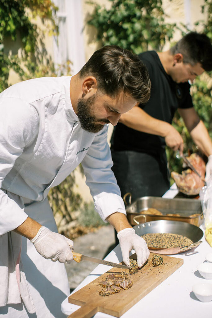 Chef preparing gourmet cuisine for a destination wedding in Italy with fresh local ingredients.