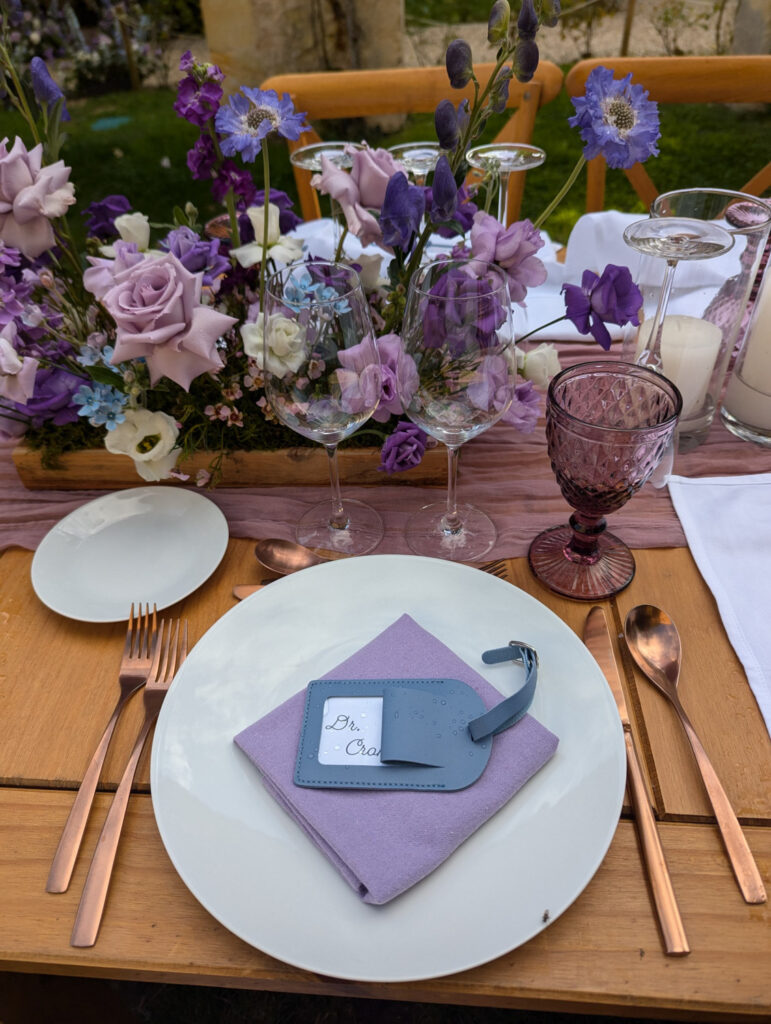Close-up of a wedding place setting with a lavender napkin and custom name tag.