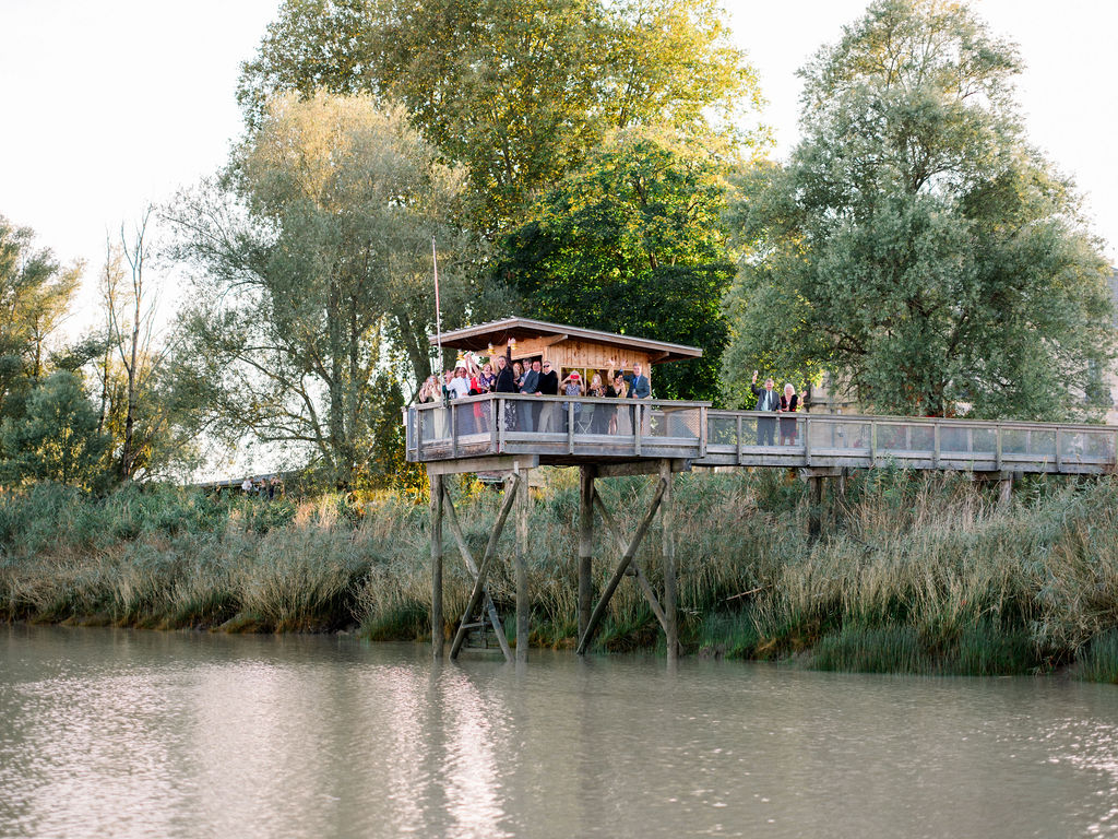 Guests gather on riverside deck for the wedding celebration in France