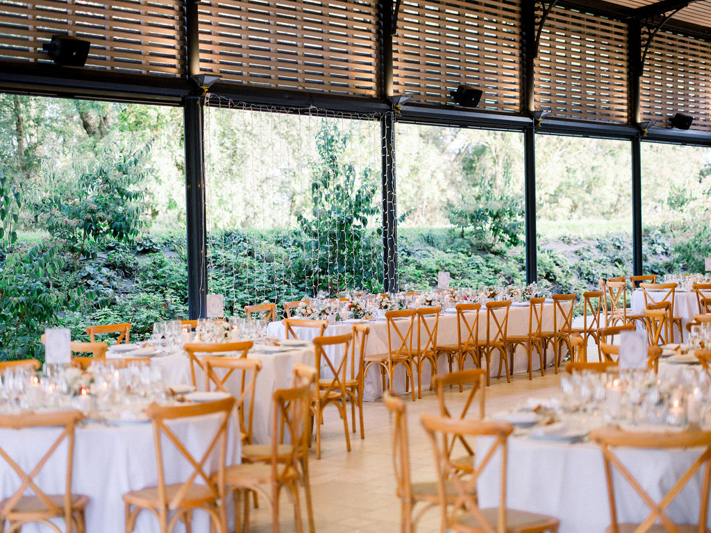 Reception tables set with florals and candles inside open-air venue space